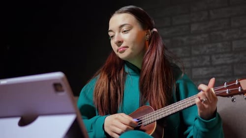 Young Woman Playing Ukulele and Smiling