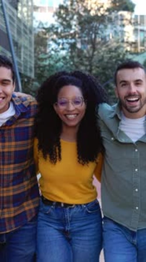 Jovens se abraçando, caminhando juntos, sorrindo para a câmera ao ar livre