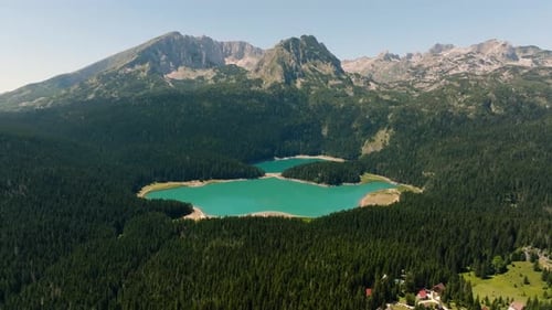 Drone view from above of the blue Black Lake surrounded by a pine forest in the mountains of Montene