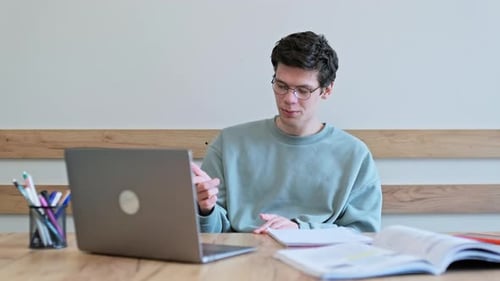 Young Adult On Video Call Studying At Desk