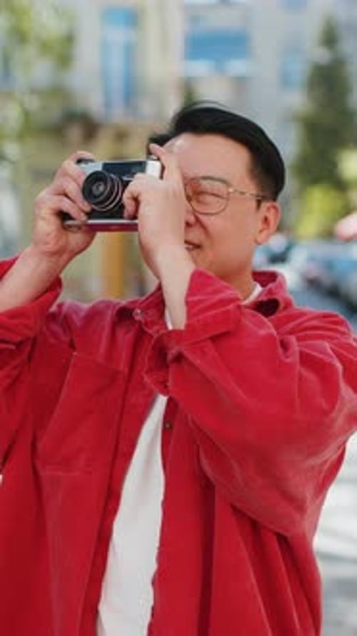 Asian Man Tourist Traveling on Weekends Exploring City Making Photo Pictures on Retro Vintage Camera