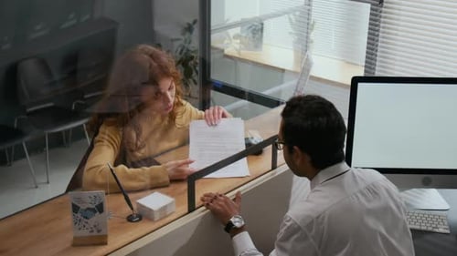 Woman Getting Help with Paperwork from Bank Assistant