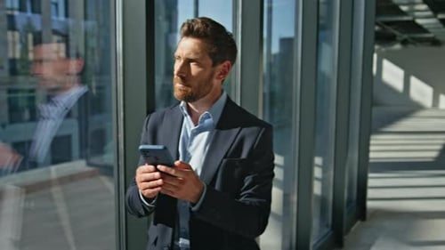 Focused Business Man Messaging on Cellphone Standing at Building Hall Closeup