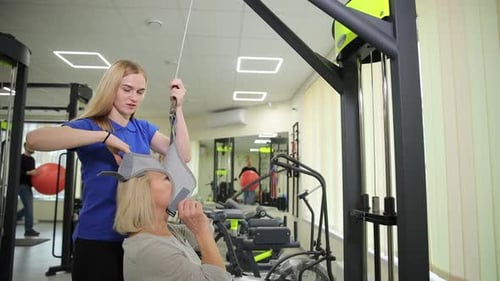 A Personal Trainer Actively Assisting a Client at the Gym During Their Workout Routine