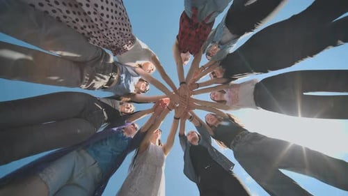 Group of Friends Joining Hands and Celebrating Outdoors