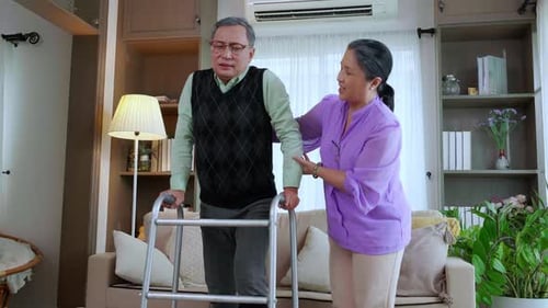 Elderly Man Using Walker, Assisted by Woman