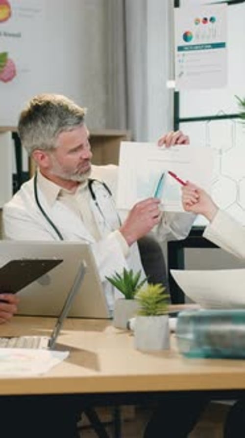 Doctors Discussing Charts in Modern Office