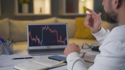 Man examining and thinking financial chart.