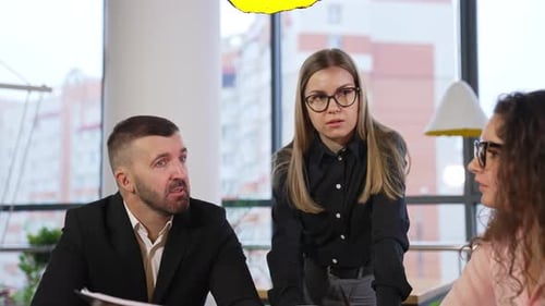 Business leader addresses his employees sitting in front of him