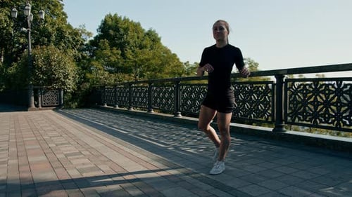 Woman Doing High Knees Exercise in Urban Park