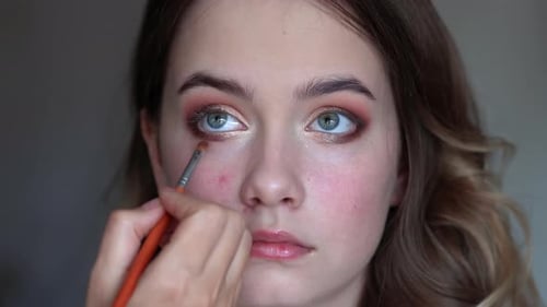 Girl Makeup Artist Paints the Eyes of a Young Girl