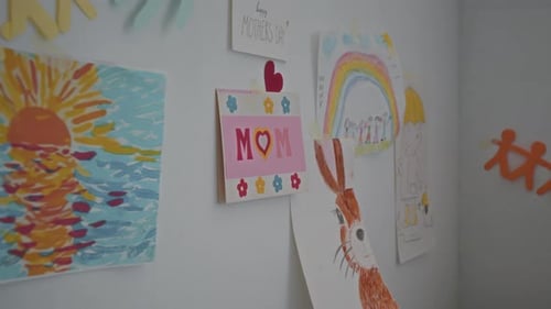 Bunte kindliche Zeichnungen und Scherenschnitte an der Wand