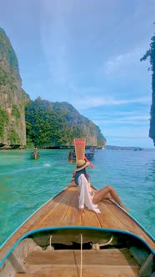 Asian Women in Front of Longtail Boat with Green Blue Turqouse Lagoon at Koh Phi Phi Thailand