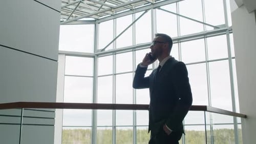 Man in Suit Talking on Phone in Modern Building