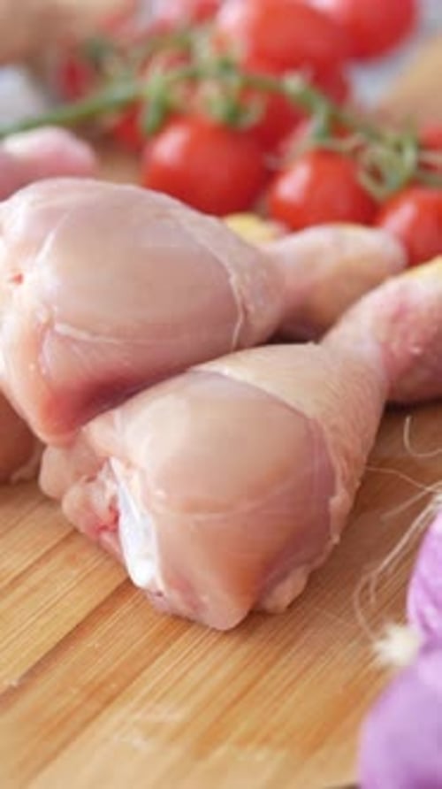 Uncooked Chicken Drumsticks with Tomatoes and Onions