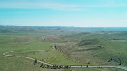 Aerial View of an Asphalt Road Through the Rural Countryside Area Wavy Road Between Little Hills