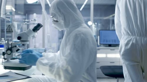 Scientists in Hazmat Suits Working in Modern Laboratory