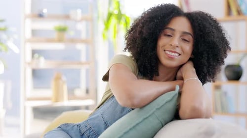 Smiling Woman with Curly Hair Relaxing on Couch