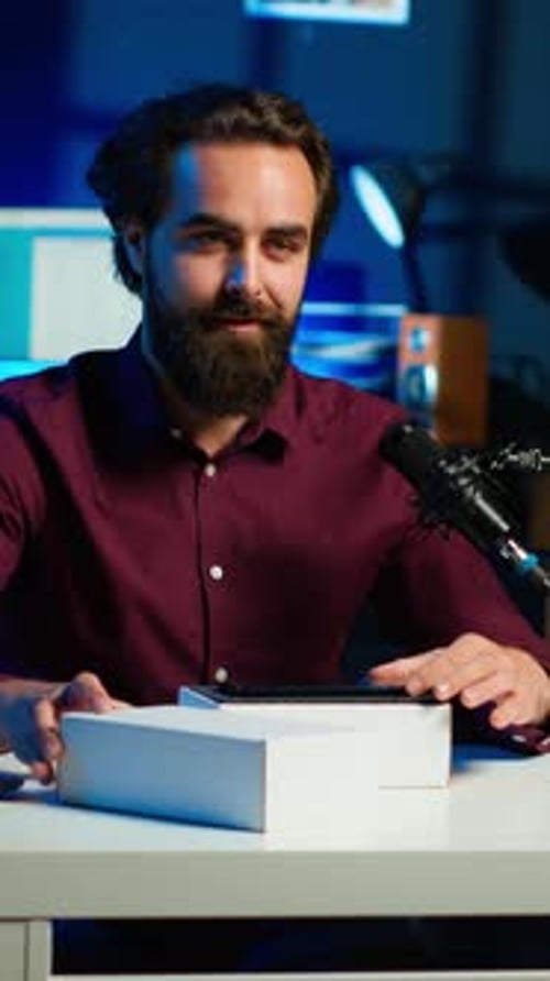 Young Adult Unboxing New Mobile Phone on Desk