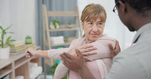 Woman Receives Arm Stretch Assistance From Caregiver