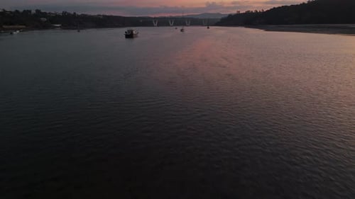 Flying Above River With Boats At Sunrise In Portugal. aerial tilt-up shot
