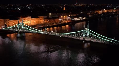 Nightlife, Cityscape with a Bridge at Budapest. Ship crosses on the river