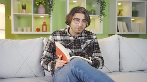 Man Relaxing and Reading a Book on Couch
