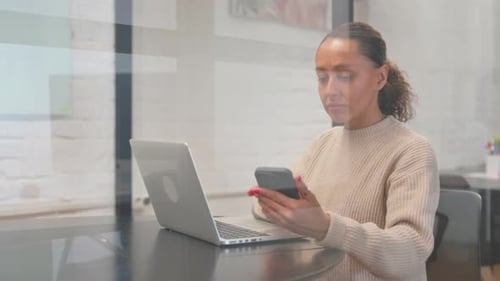 Woman Works on Laptop, Using Mobile Phone
