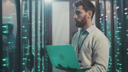 Technician Diligently Checks Network Hardware Inside Quiet Data Center with Gentle Hum and Indicator