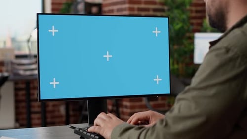 Person Typing at Computer with Chroma Key Screen