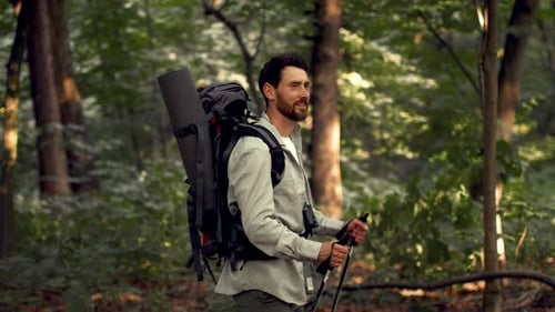 Man With Light Skin Walks in Forest With Hiking Gear and Backpack During Daytime