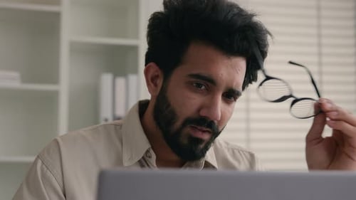 Man Rubbing Eyes in Office with Computer