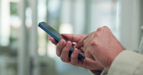 Man's Hands Using Blue Cell Phone Indoors