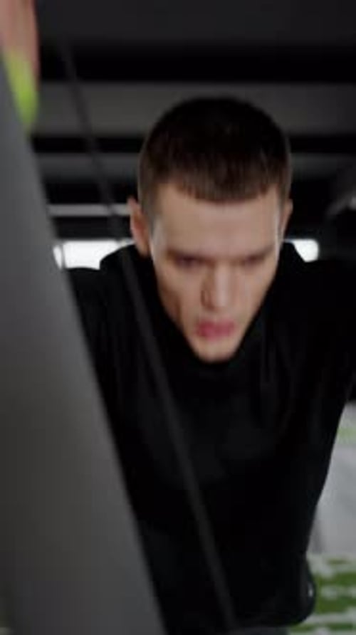 Young Man Working Out on a Cable Machine at a Modern Gym