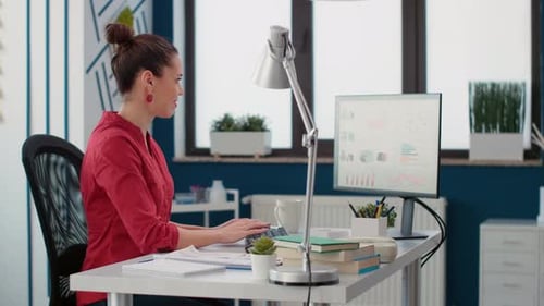Woman Working with Data on Computer in Office