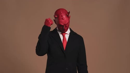 Empresario del Diablo Rojo con cuernos golpeándose en la cabeza y sacudiendo la cabeza negativamente