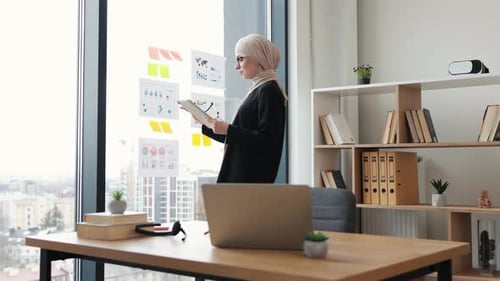 Business Woman Analyzes Charts in Modern Office