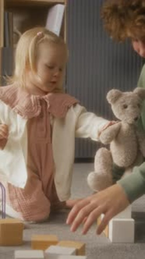 Cute Blonde Child Playing with Parent and Toys