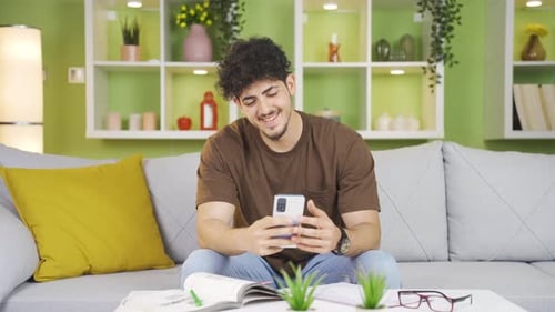 Man Using Smartphone on Couch at Home