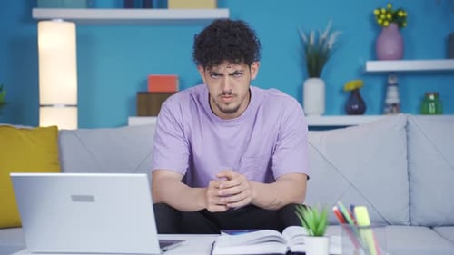 Young Adult Talking in Front of Laptop at Home