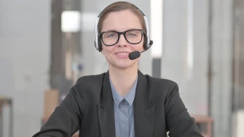 Junge Frau mit Headset lächelt im Call Center