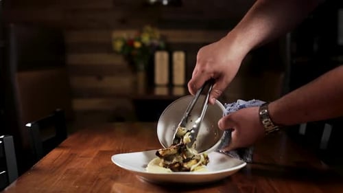 El chef sirve verduras asadas en un plato. - de cerca