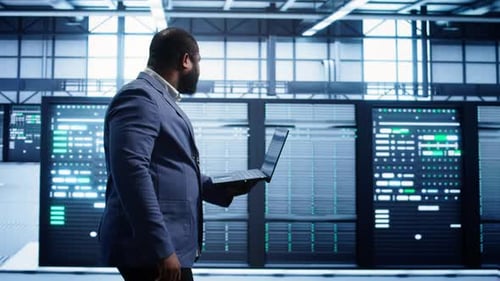 Man Using Laptop in Modern Server Room