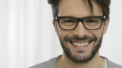 Nahaufnahme eines lächelnden jungen Mannes mit Brille. Porträt von Happy Guy With