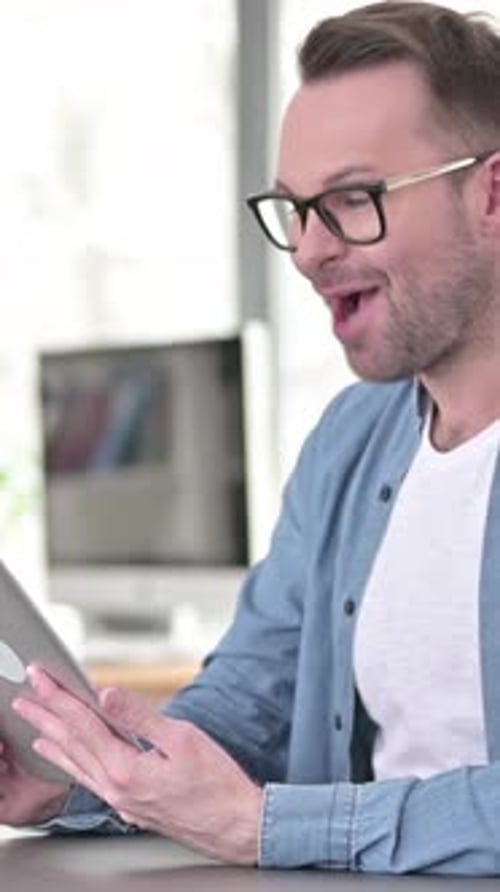 Smiling Man Video Chatting on Tablet Device Indoors