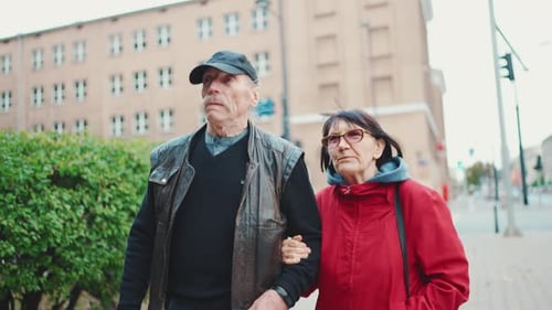 Elderly married couple walking through the modern city of Warsaw, Poland