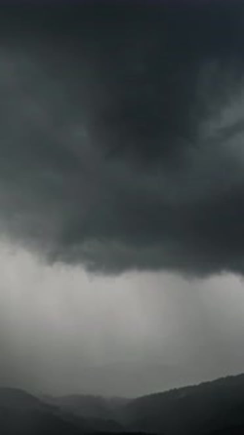Dark Clouds Over Distant Mountain Peaks
