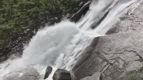 Close slowmotion drone shot following down a powerful waterfall in Norway with strong current going