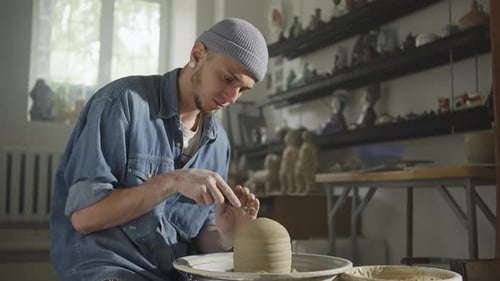 Young Adult Potter at Wheel Shaping Clay