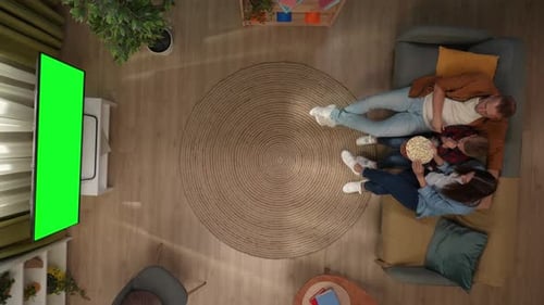 Top View of Living Room Mother Father and Son Sitting on the Sofa Eating Popcorn Watching Scary